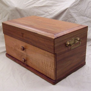 Wooden storage box with two small drawers and a hinged lid.