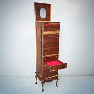 Tall, vintage wooden chest of drawers with a mirror on top. It features multiple compartments, including a partially opened drawer with red lining.